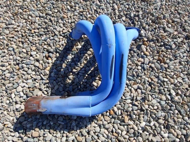 Blue-coated header photographed outdoors on gravel.