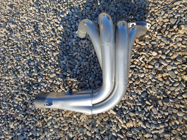Coated headers photographed outdoors on gravel.